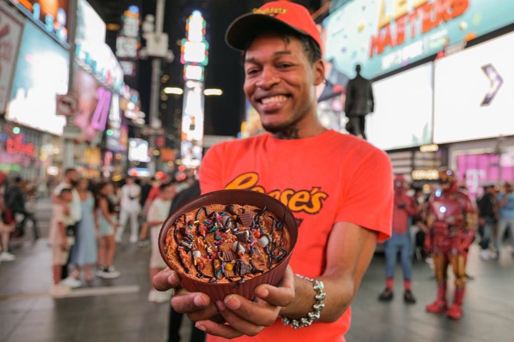 Man Holding Reese's Cup in Times Square