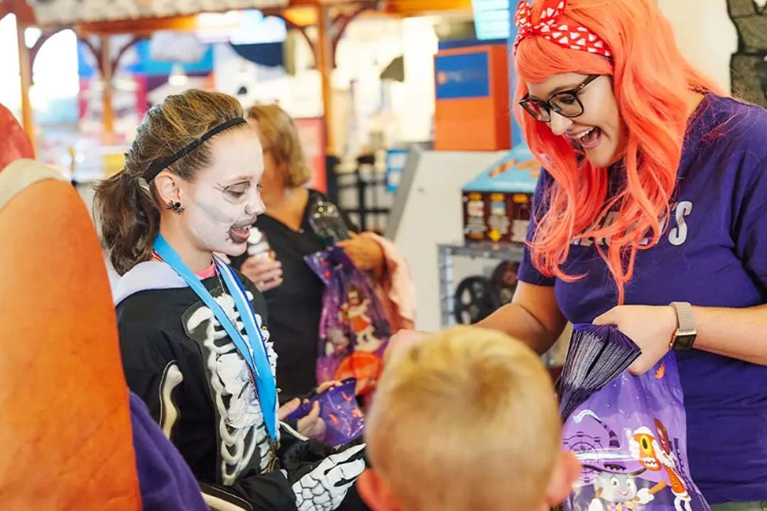 chocolate world employee handing out hersheys candy to trick or treaters